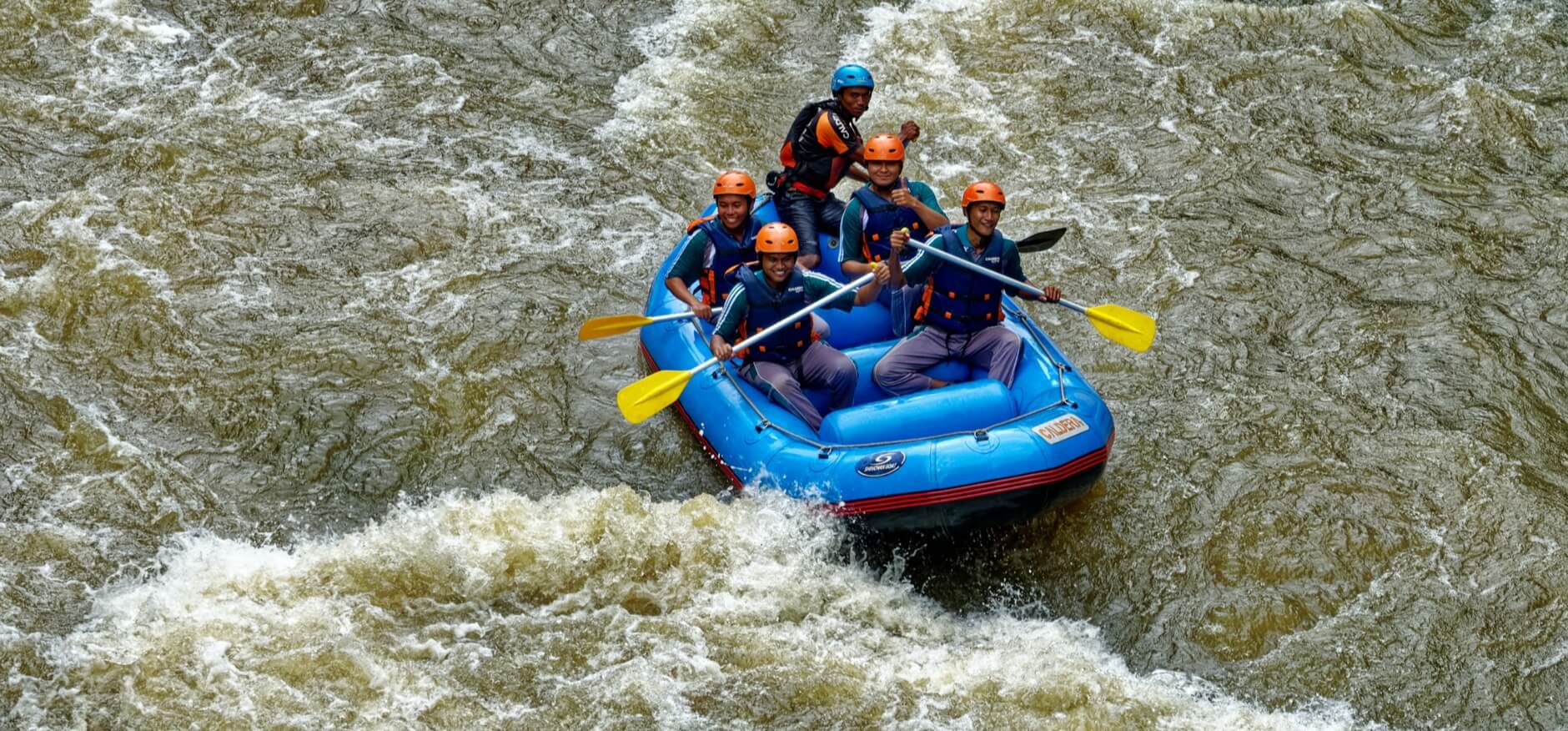 Imagery of a group of people enjoying a white-water rafting travel experience
